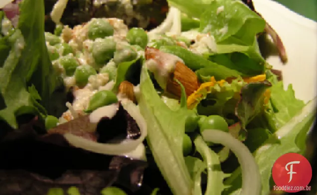 Salada verde mista com ervilhas recém-descascadas e flores comestíveis