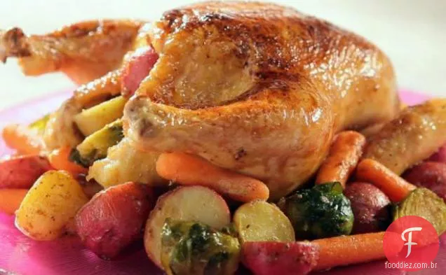 Frango envidraçado de bordo com legumes assados do país