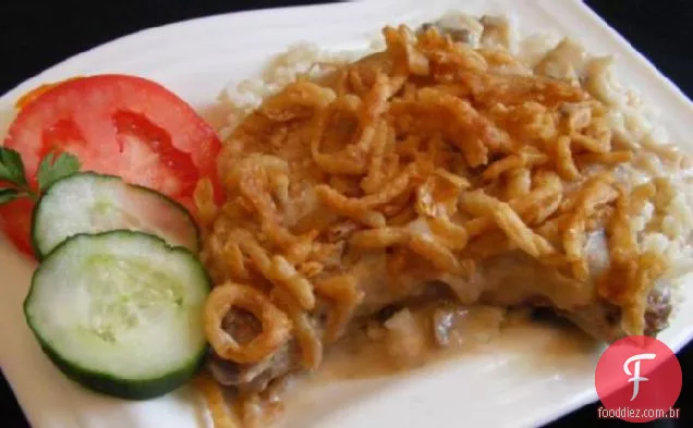 Costeletas de porco sufocadas com molho e arroz