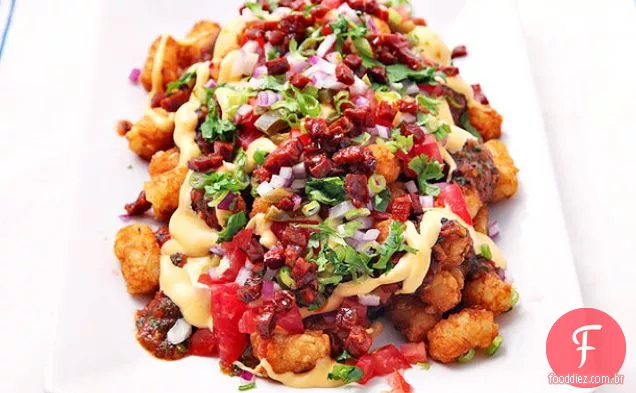Totchos (Tater Tot Nachos) com molho de queijo, molho de tomate carbonizado, chouriço e Jalapeños em conserva