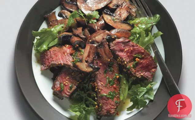 Bife Asiático queimado e cogumelos em verduras misturadas com molho de gengibre