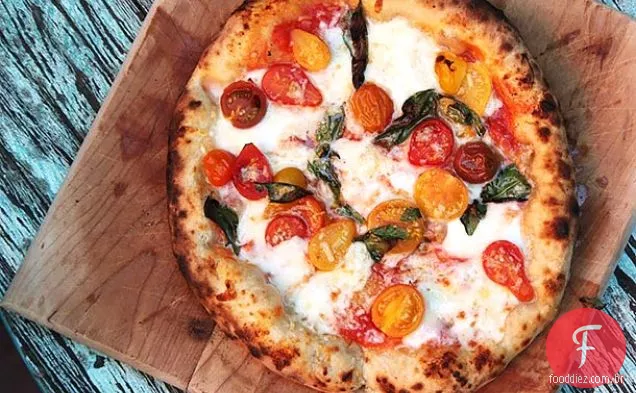 Pizza com tomate cereja, alho, manjericão e mussarela