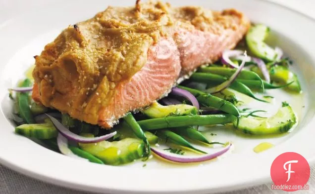 Salmão rei selvagem do Alasca com crosta de Hummus sobre uma cama de feijão francês, cebola roxa e salada de pepino com óleo de limão