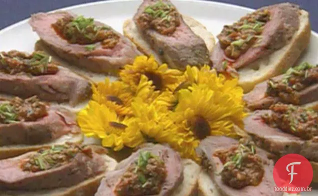Lombo de cordeiro com crosta de alho e pimenta com Hash de tomate servido em Crostini