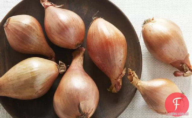 Perna de cordeiro com azeitonas verdes, ameixas e chalotas assadas