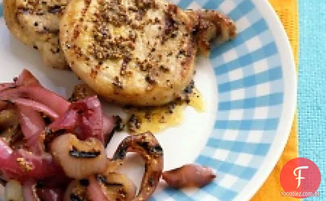 Costeletas de porco e cebolas revestidas com mostarda