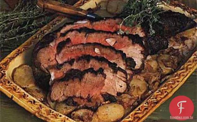 Perna assada de cordeiro com batatas e cebolas