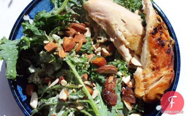 Salada de frango assado e couve à frente com tahine, damascos e amêndoas