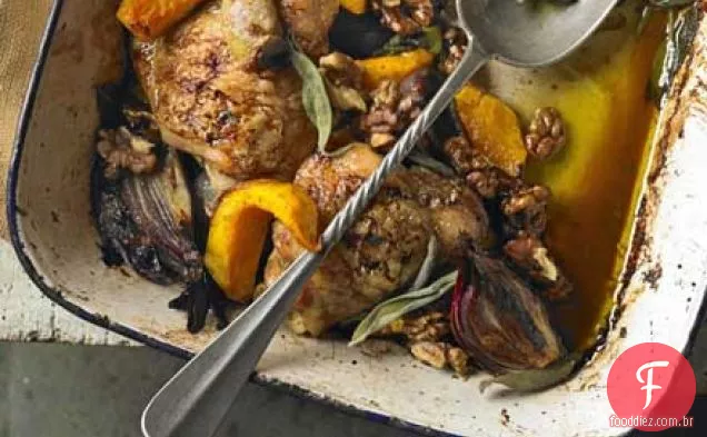 Frango assado em uma panela com abóbora, sálvia e nozes