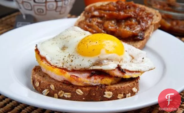 Sanduíche de café da manhã com bacon de Peameal com cebola caramelizada de bordo e um ovo frito