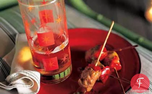 Espetos de carne de porco e pimenta vermelha temperados com molho meteórico de Manga