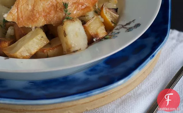 Frango assado saboroso com limão, alho e batatas