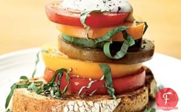 Salada de tomate em herança empilhada com creme Ricotta Salata