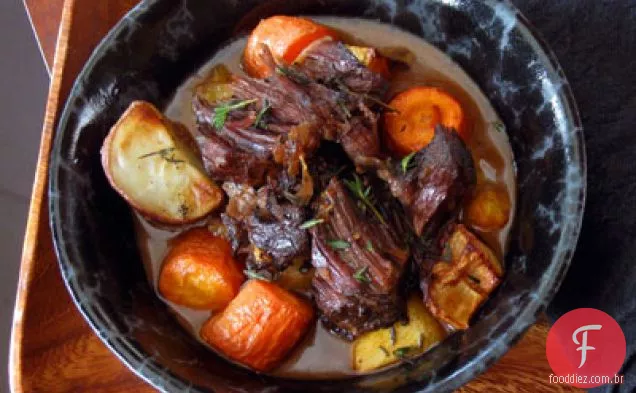 Panela de alho assada com batatas assadas e vegetais de raiz