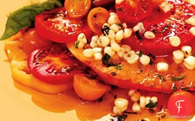 Tomates fatiados com milho e manjericão