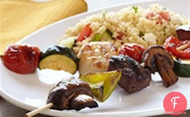 Kabobs do bisão do mar e da costa com Salada mediterrânea do Cuscuz
