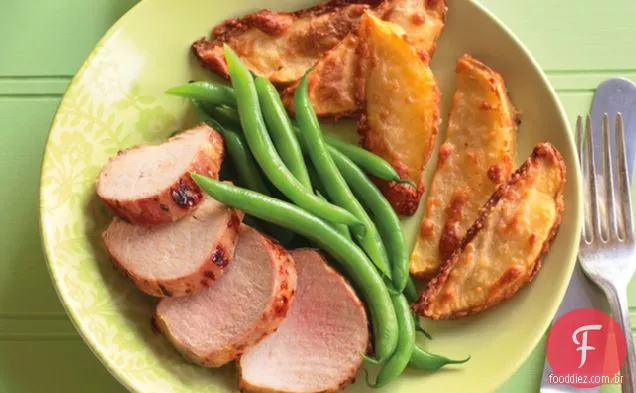 Carne de porco assada em uma panela com batatas fritas com parmesão