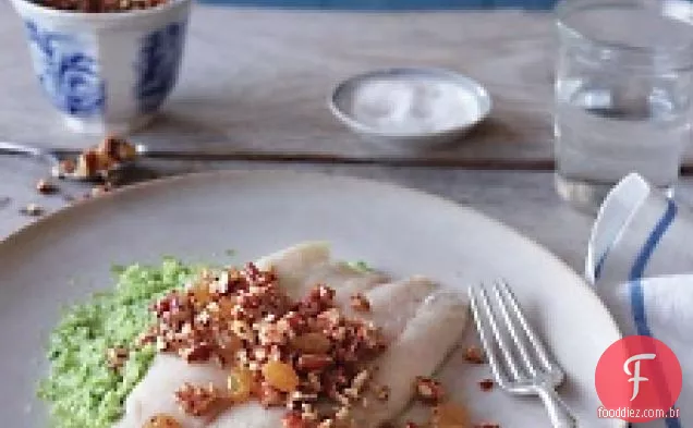 Barramundi com molho de nozes e passas sobre brócolis