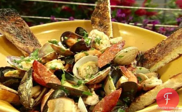 Salsicha andouille grelhada com camarão, amêijoas, mexilhões e alho com pão grelhado com manteiga de anchova