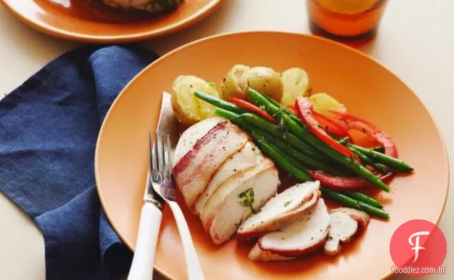Frango recheado com queijo azul embrulhado com Bacon, feijão verde e batatas esmagadas com cebolinha