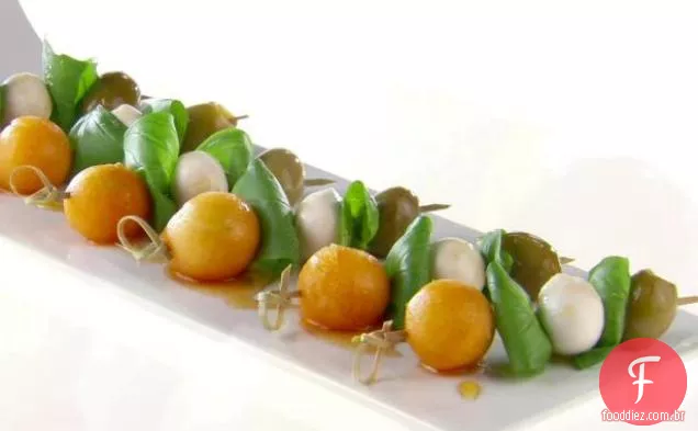 Mini espetos de melão e azeitona com mel de pimenta preta