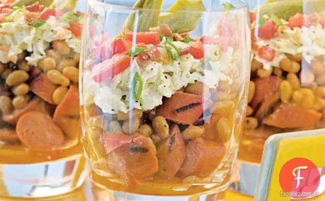 Saladas de churrasco em camadas com cachorros-quentes grelhados
