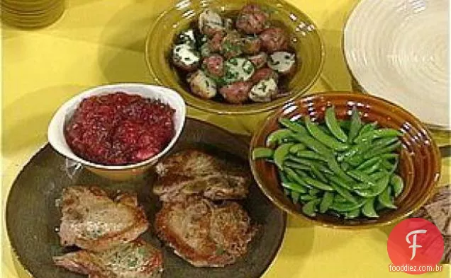 Costeletas de porco com molho de Cran-maçã, batatas de salsa e ervilhas de açúcar