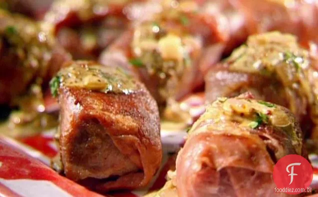 Cubos de carne embrulhados em presunto com molho de mostarda