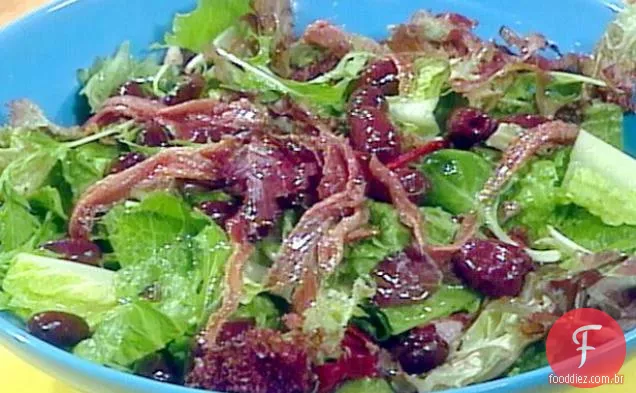 Salada verde misturada com limão, azeitonas e anchovas