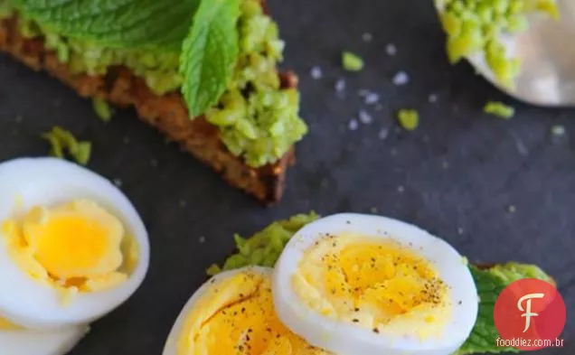 Ovos cozidos com purê de ervilhas e Edamame sobre torradas sem glúten