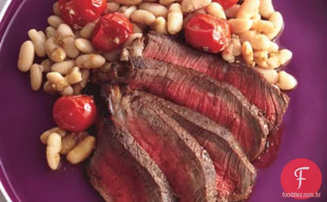 Bife esfregado com especiarias com feijão branco e tomate cereja