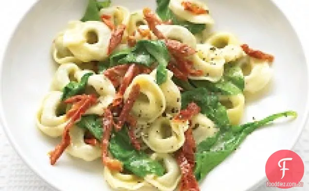 Tortellini de carne com rúcula e tomates secos ao sol