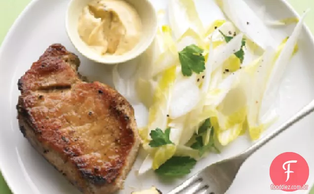 Costeletas de porco com salada Endive e mostarda cominho