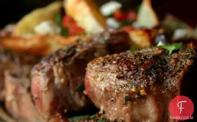 Costeletas de cordeiro e batatas com azeitonas, tomates e queijo Feta