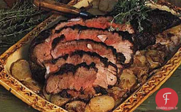 Perna assada de cordeiro com batatas e cebolas